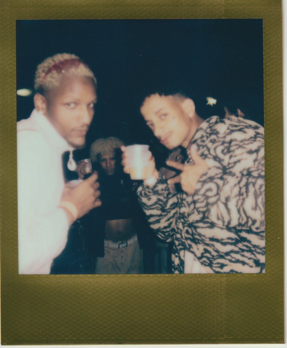 Three people toasting with cups at night