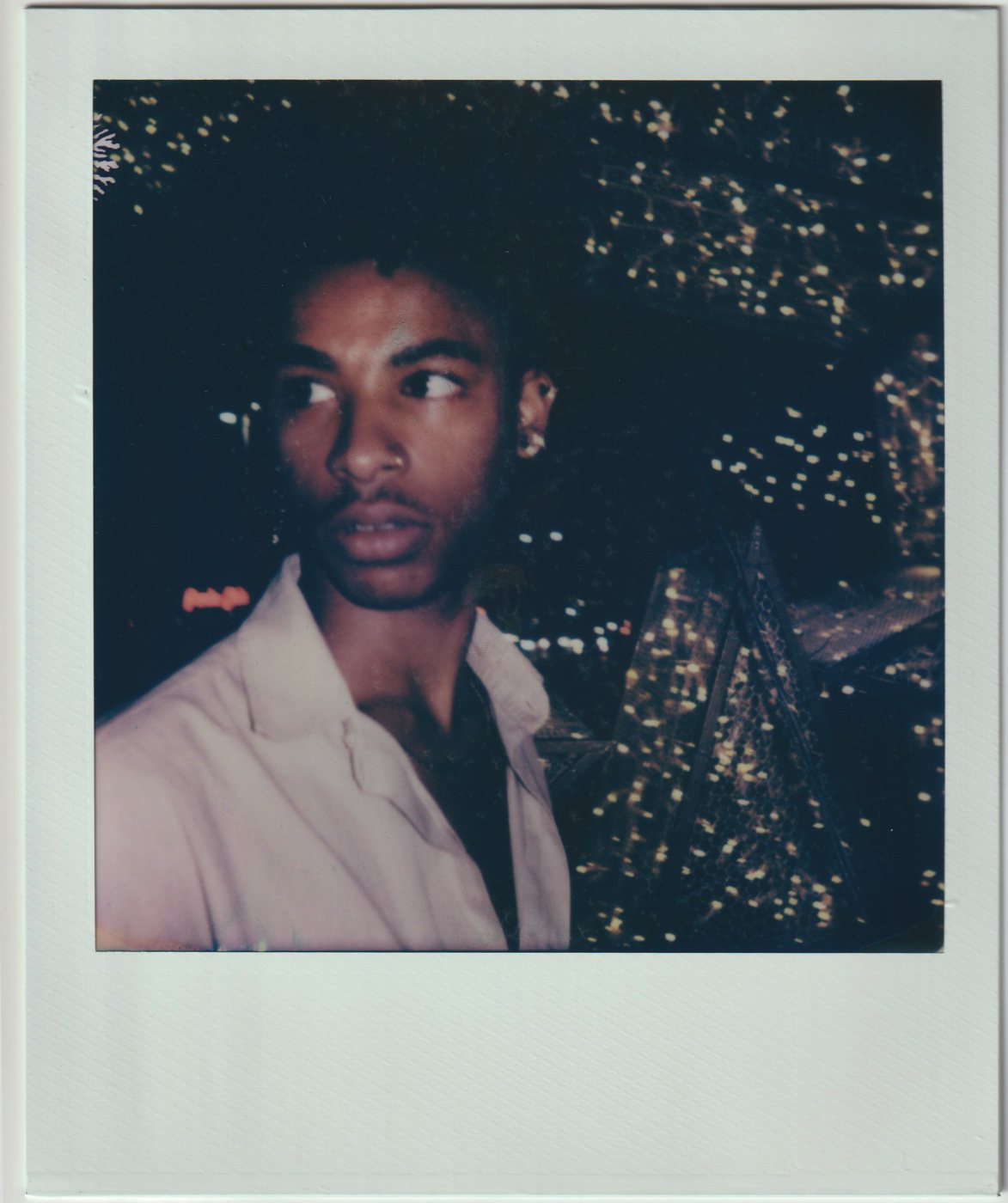 Portrait of a person at night before a wall of lights